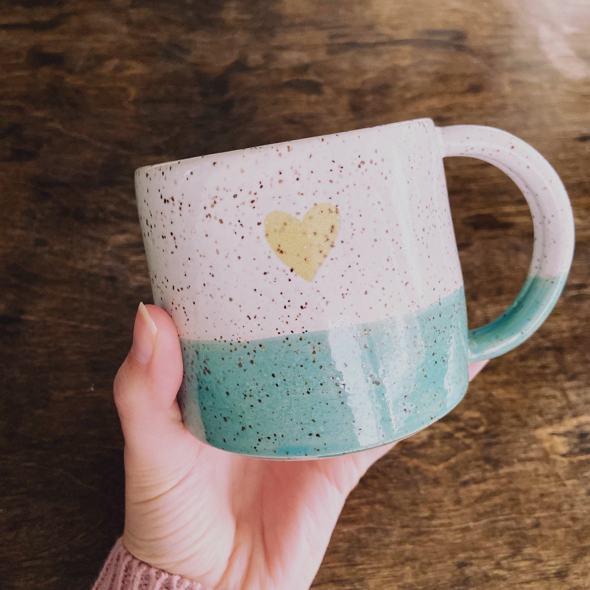 Handmade Ceramic Speckled Mug with teal bottom and yellow heart in the center of the mug, made by Heart and Hope Inc from Calgary Canada